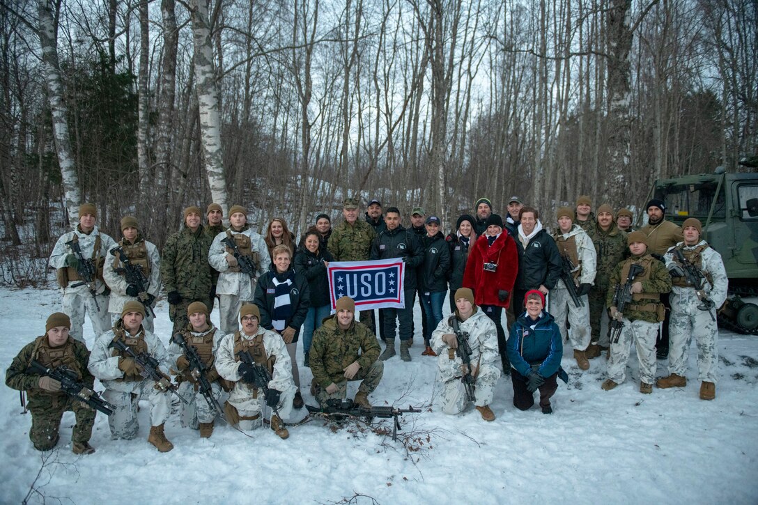 Marine Corps Gen. Joe Dunford and his wife pose for a photo with troops and performers in the snow.