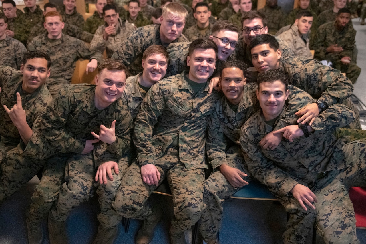 Service members smile and pose for a group shot.