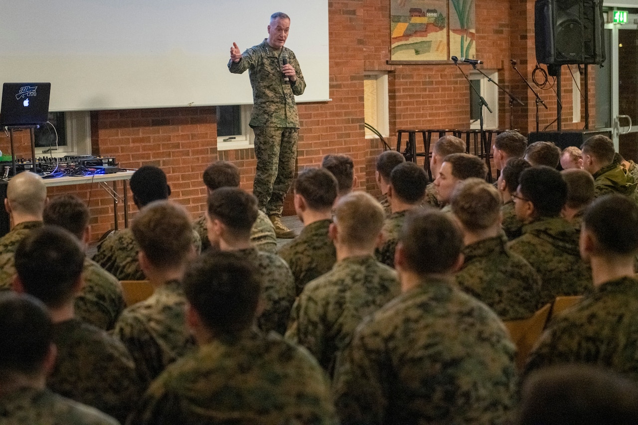 Marine Corps Gen. Joe Dunford talks on a stage to an audience of troops.