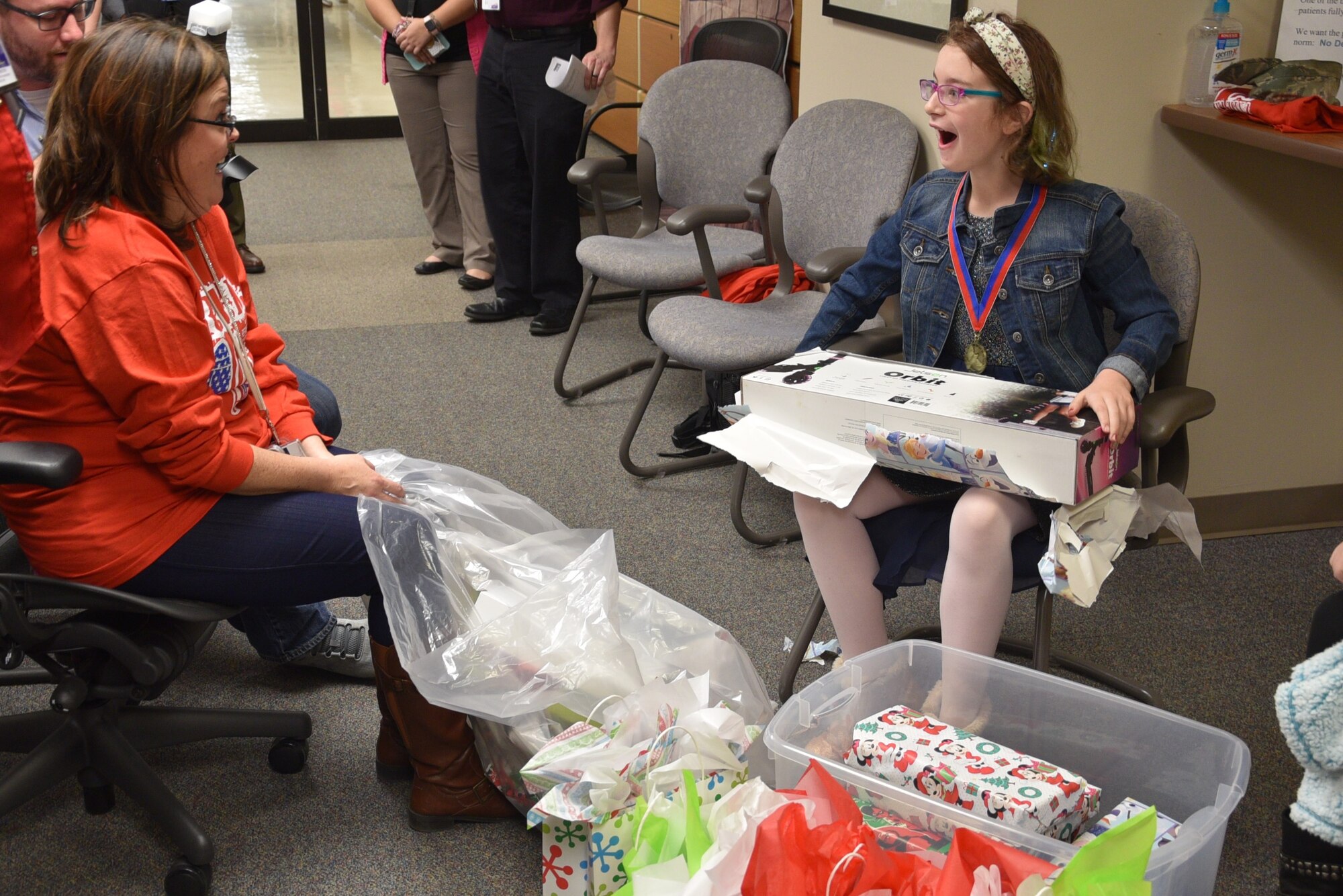 The daughter of Staff Sgt. Joshua Gunner, 552nd Air Control Wing, receives an electric scooter from Veteran Experience Specialist Tammie Mayfield at the Oklahoma City Veteran Affairs Health Care System in celebration of Remember Everyone Deployed, a new program designed to recognize families of deployed members during the holidays on Dec. 19.  (U.S. Air Force photo/2nd Lt. Ashlyn K. Paulson)