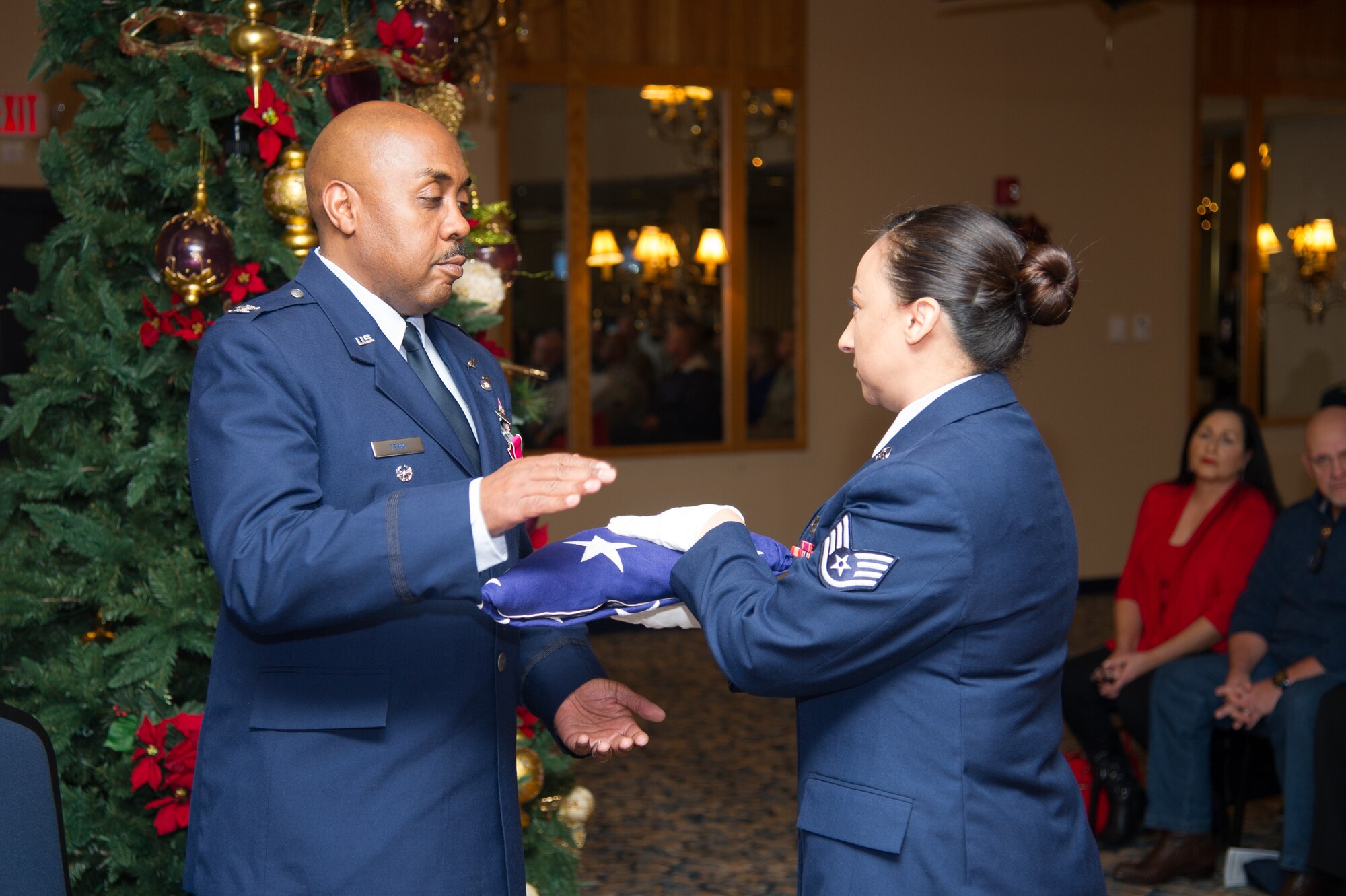Col. Lloyd Terry is presented with an American Flag by Staff Sgt. Michelle Vallejo during his retirement ceremony, Friday, December 14, at Naval Air Station Fort Worth Joint Reserve Base, Texas, culminating a 35 year career.