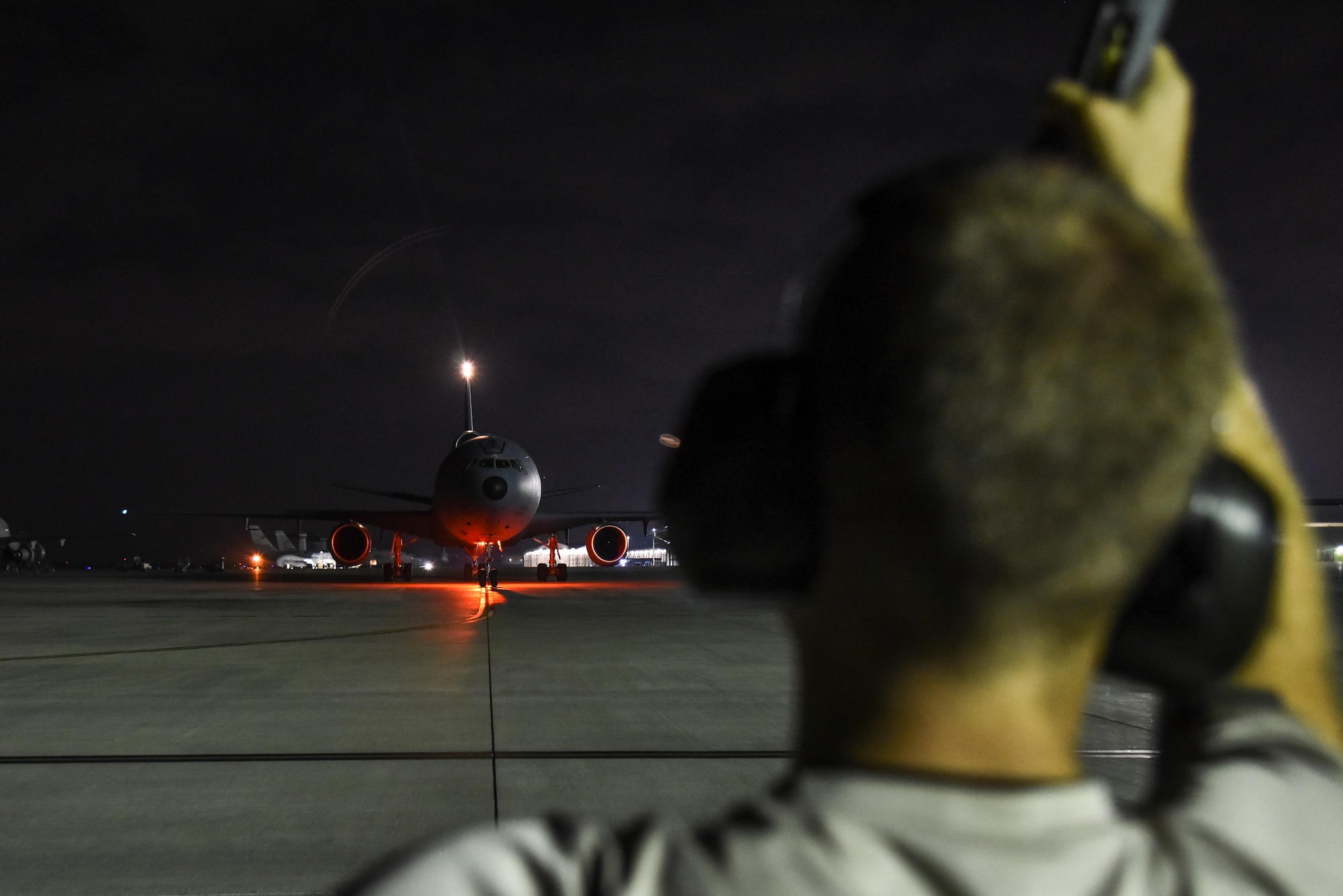 U.S. Air Force Senior Airman Chase Doyen, 380th Expeditionary Aircraft Maintenance Squadron KC-10 Extender crew chief, marshalls a KC-10 upon landing at Al Dhafra Air Base, United Arab Emirates, Dec. 18, 2018. The crew chief’s extensive list of responsibilities including for pre-, post- and thru-flight checks, and well as various inspections, allows them to fully understand their vital role, making them jacks-of-all-trades when it comes to repairing the aircraft. (U.S. Air Force photo by Senior Airman Mya M. Crosby)