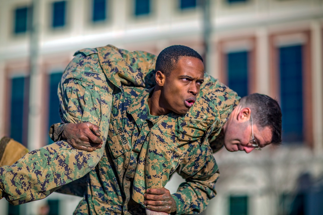 A Marine carries another Marine on his shoulders.