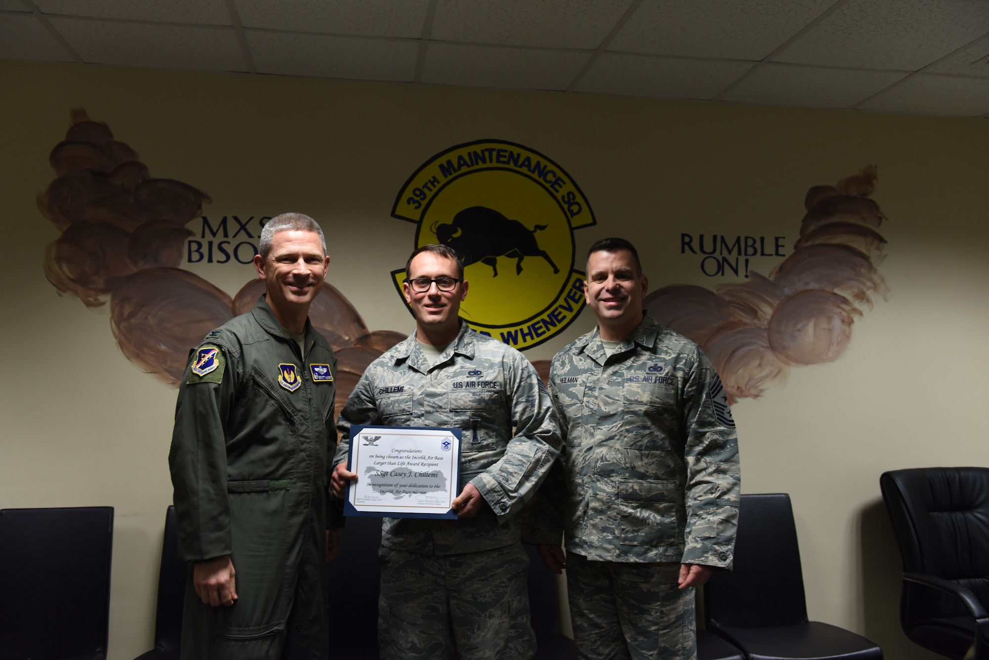 Airman holds up Larger Than Life Award.