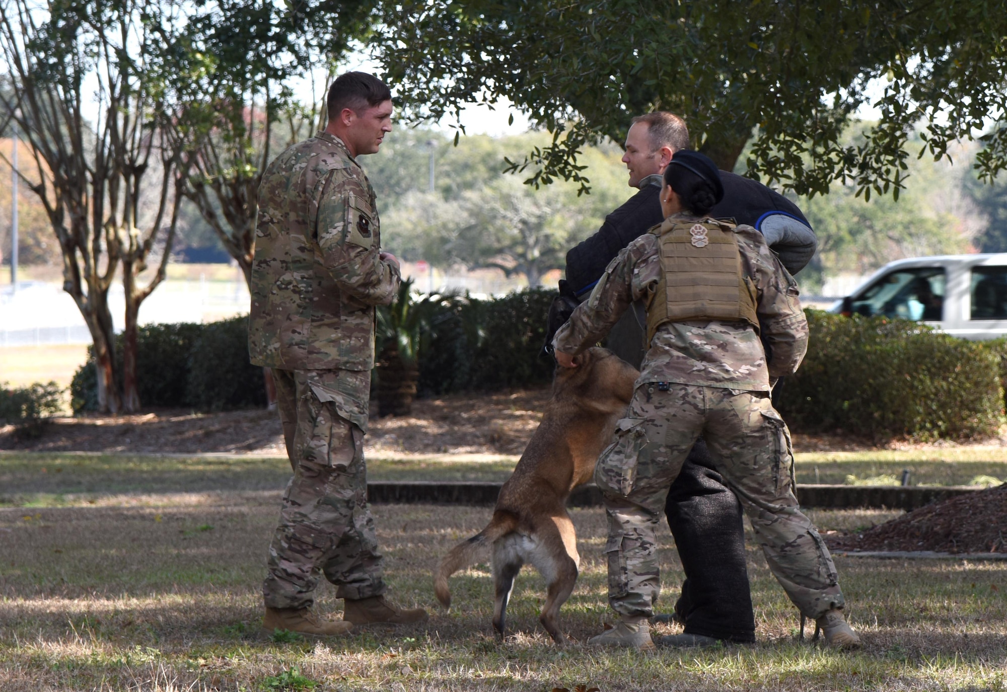 U.S. Air Force Staff Sgt. William Herron, left, 81st Security Forces Squadron military working dog kennel master, Senior Airman Tilar Robinson, 81st SFS military working dog handler, and Maj. Matthew Roberts, 81st Logistics Readiness Squadron commander, participate in a military working dog demonstration during the 81st SFS Day In The Life Of A Defender event at Keesler Air Force Base, Mississippi, Dec. 18, 2018. The event, which was the kick-off for the Year Of The Defender, allowed the 81st SFS to showcase their training and mission capabilities to Keesler leadership. (U.S. Air Force photo by Kemberly Groue)