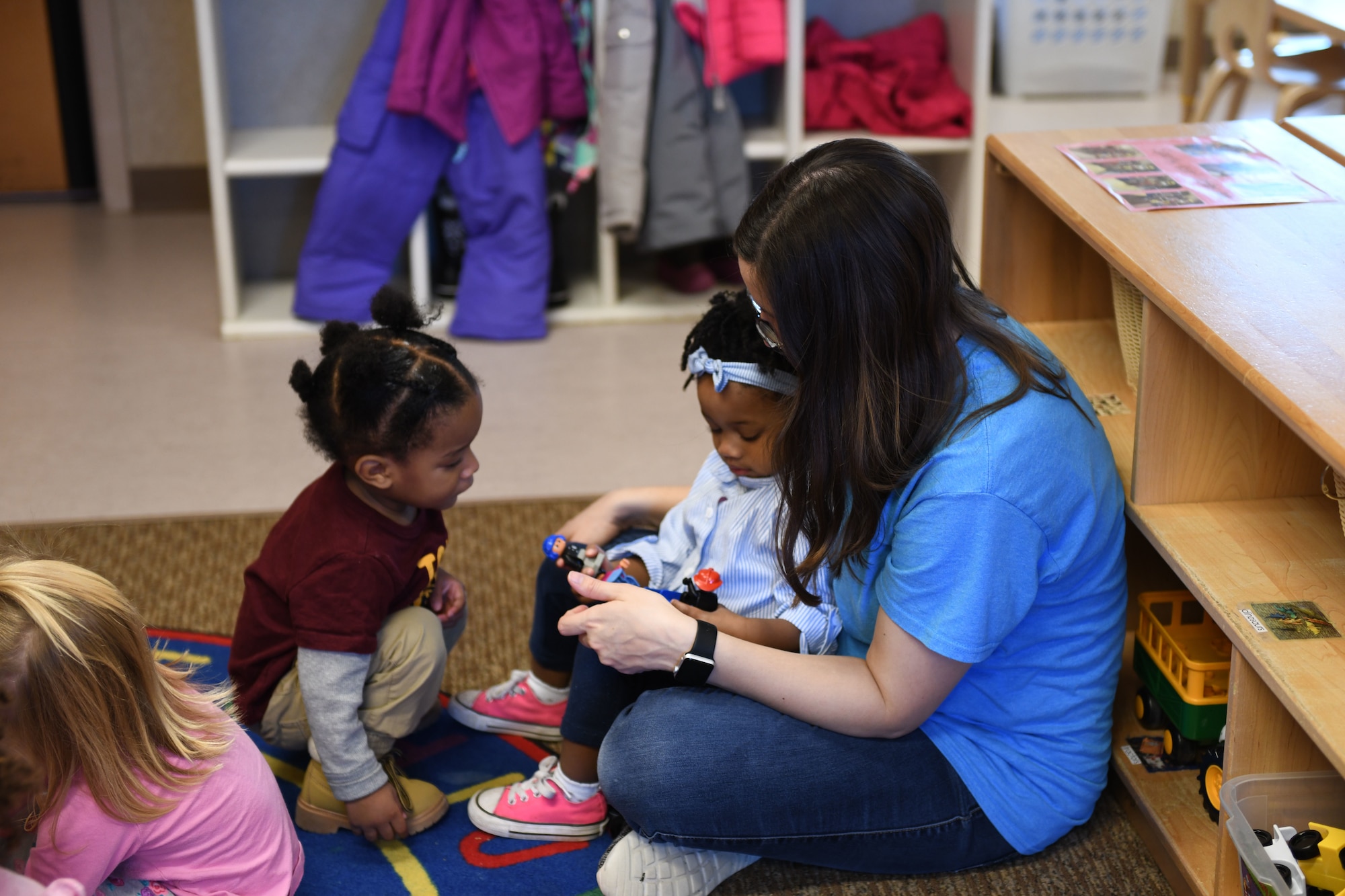 Ali Stegeman, a 28th Force Support Squadron child and youth program assistant, plays with children from room 138 at the McRaven Child Development Center on Ellsworth Air Force Base, S.D., Dec. 6, 2018. At the CDC, children are taught to share and play respectfully with others. (U.S. Air Force photo by Airman 1st Class Christina Bennett)