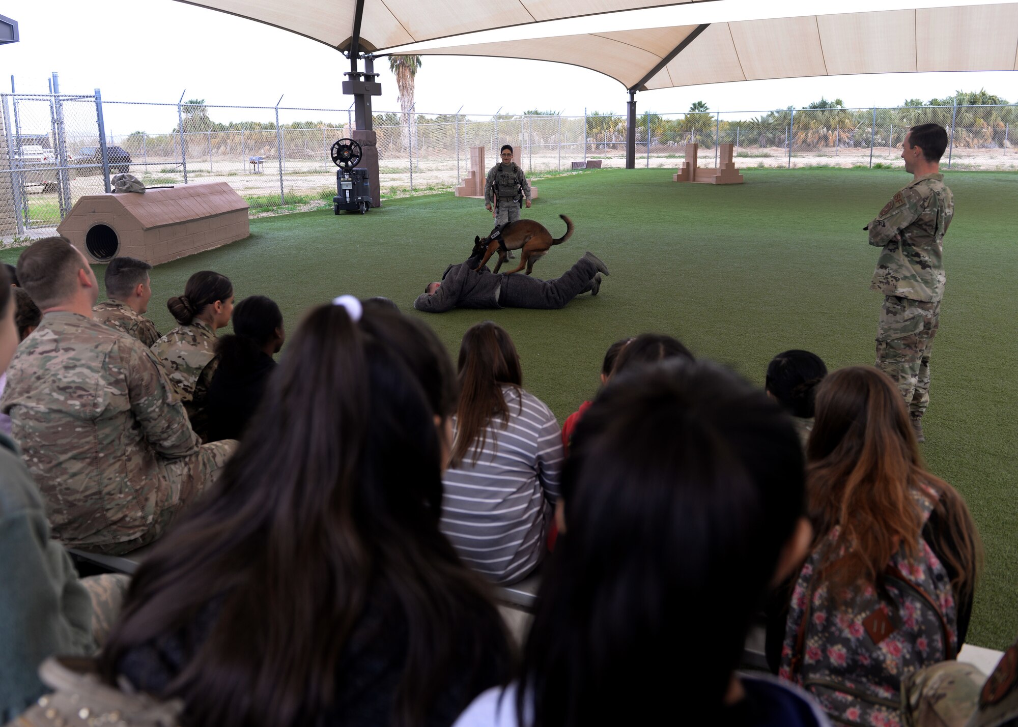 56th Security Forces Squadron military working dog handlers demonstrate how a MWD apprehends a suspect during the “Day of Hope” event at Luke Air Force Base, Ariz., Dec. 21, 2018.