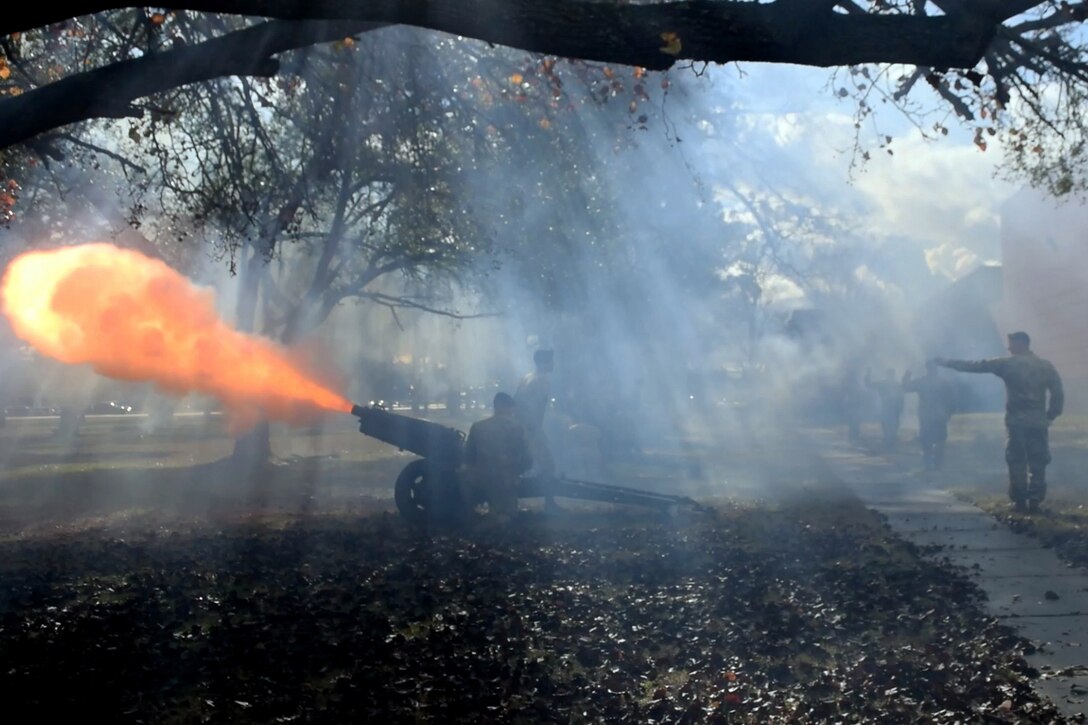 Soldiers fire a salute with a cannon.