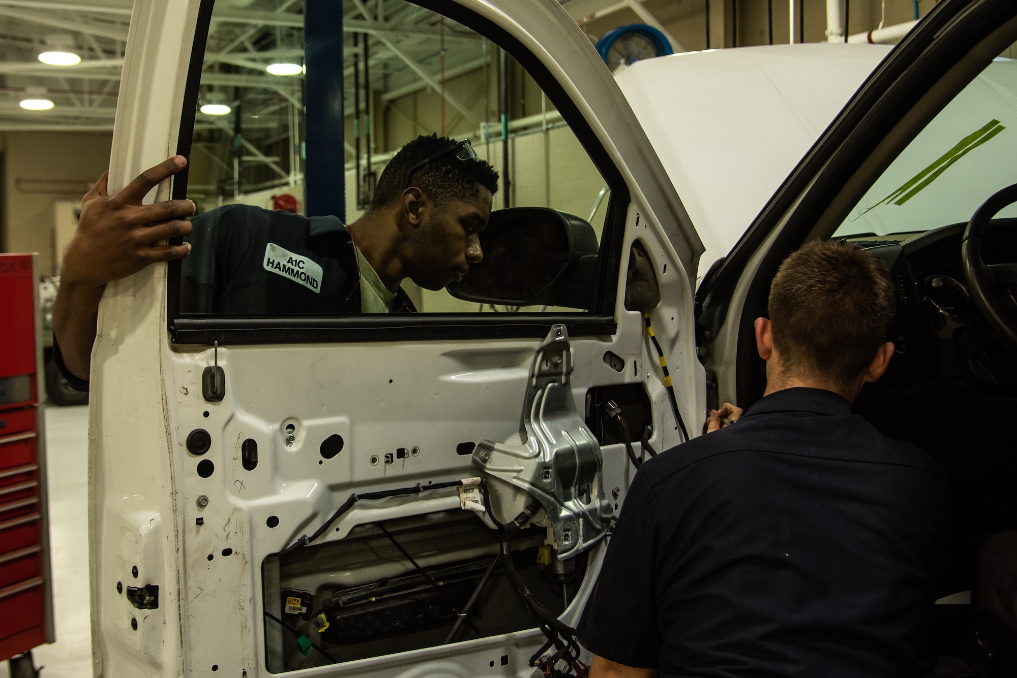 U.S. Air Force Airman 1st Class Darius Hammond, 20th Logistics Readiness Squadron vehicle maintenance apprentice, left, holds a door while Airman 1st Class Brady McGrail, 20th LRS firetruck and refueling truck mechanic tightens a bolt at Shaw Air Force Base, S.C., Dec. 20, 2018.