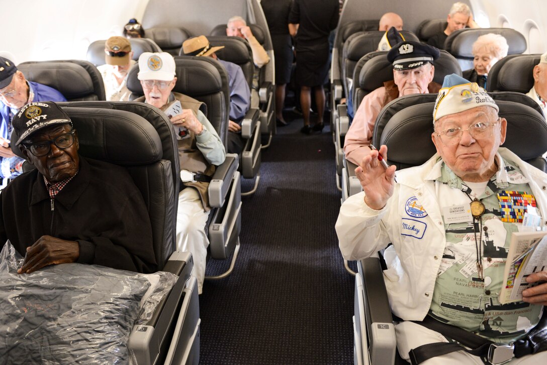 A group of veterans seated inside an airplane.