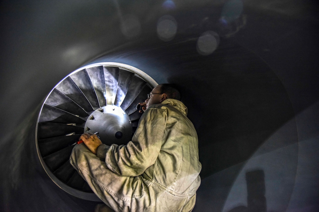 An airman inspects an unmanned aerial vehicle's turbines.