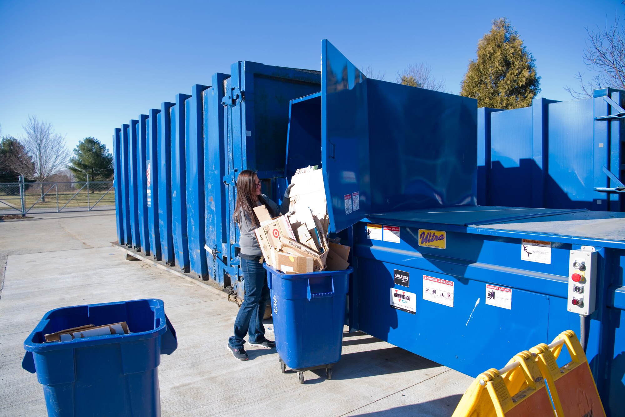 April Mota, 434th CES materials examiner and identifier, loads cardboard into a new trash compactor at Grissom Air Reserve Base, Ind., Dec. 26, 2018. The two new compactors allow Grissom to more effectively recycle the large quantities of cardboard and paper waste it produces each week. (U.S. Air Force photo / Senior Airman Harrison Withrow)