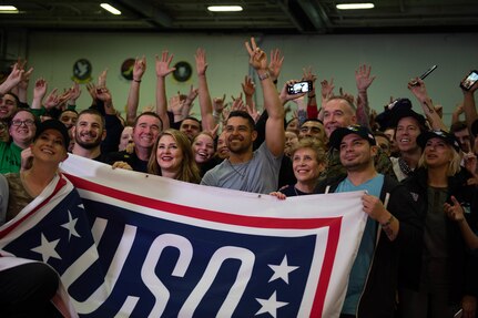 U.S. Sailors and members of a USO tour pose for a photo in the hangar bay aboard the aircraft carrier USS John C. Stennis (CVN 74) in the Arabian Gulf, Dec. 23, 2018. The John C. Stennis Carrier Strike Group is deployed to the U.S. 5th Fleet area of operations in support of naval operations to ensure maritime stability and security in the Central Region, connecting the Mediterranean and the Pacific through the western Indian Ocean and three strategic choke points.