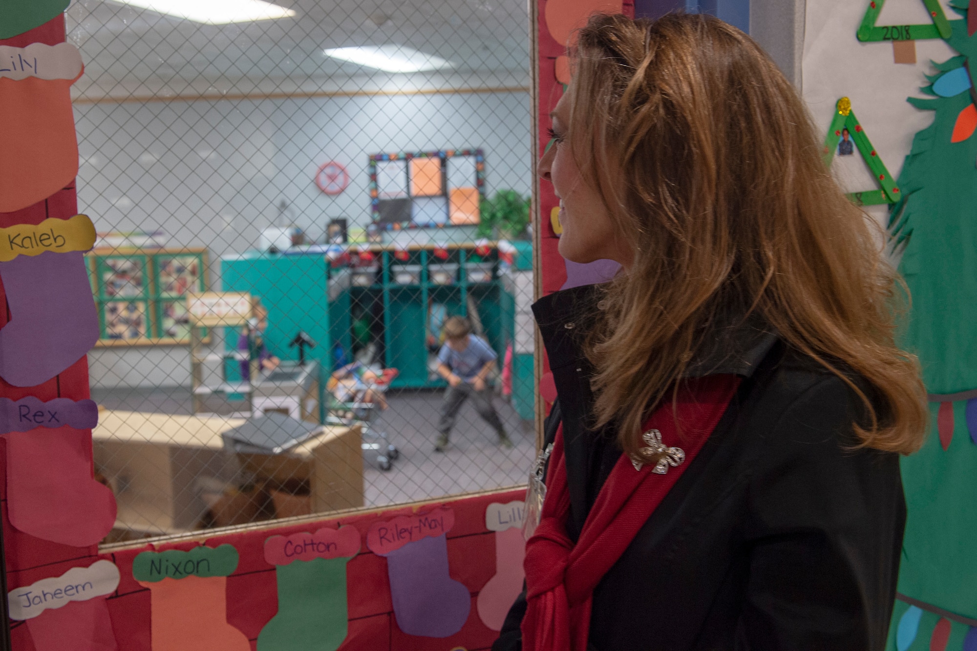 Joni Kwast, wife of U.S. Air Force Lt. Gen. Steven Kwast, commander of Air Education and Training Command, watches children play at the Child Development Center, Dec. 18, 2018, at Altus Air Force Base, Okla. The tours were designed so they could learn more about the inner workings of the base and how AETC can support it in future operations. (U.S. Air Force Photo by Senior Airman Jackson N. Haddon)