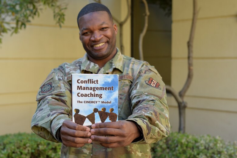 U.S. Air Force Tech. Sgt. Piankhy Richberg, 60th Air Mobility Wing Equal Opportunity NCO in charge, holds a conflict management coaching book Dec. 17, 2018, at Travis Air Force Base, California. The EO office implemented conflict management coaching in June 2018. Since the program’s inception, 11 people have used the program. (U.S. Air Force photo by Tech. Sgt. James Hodgman)
