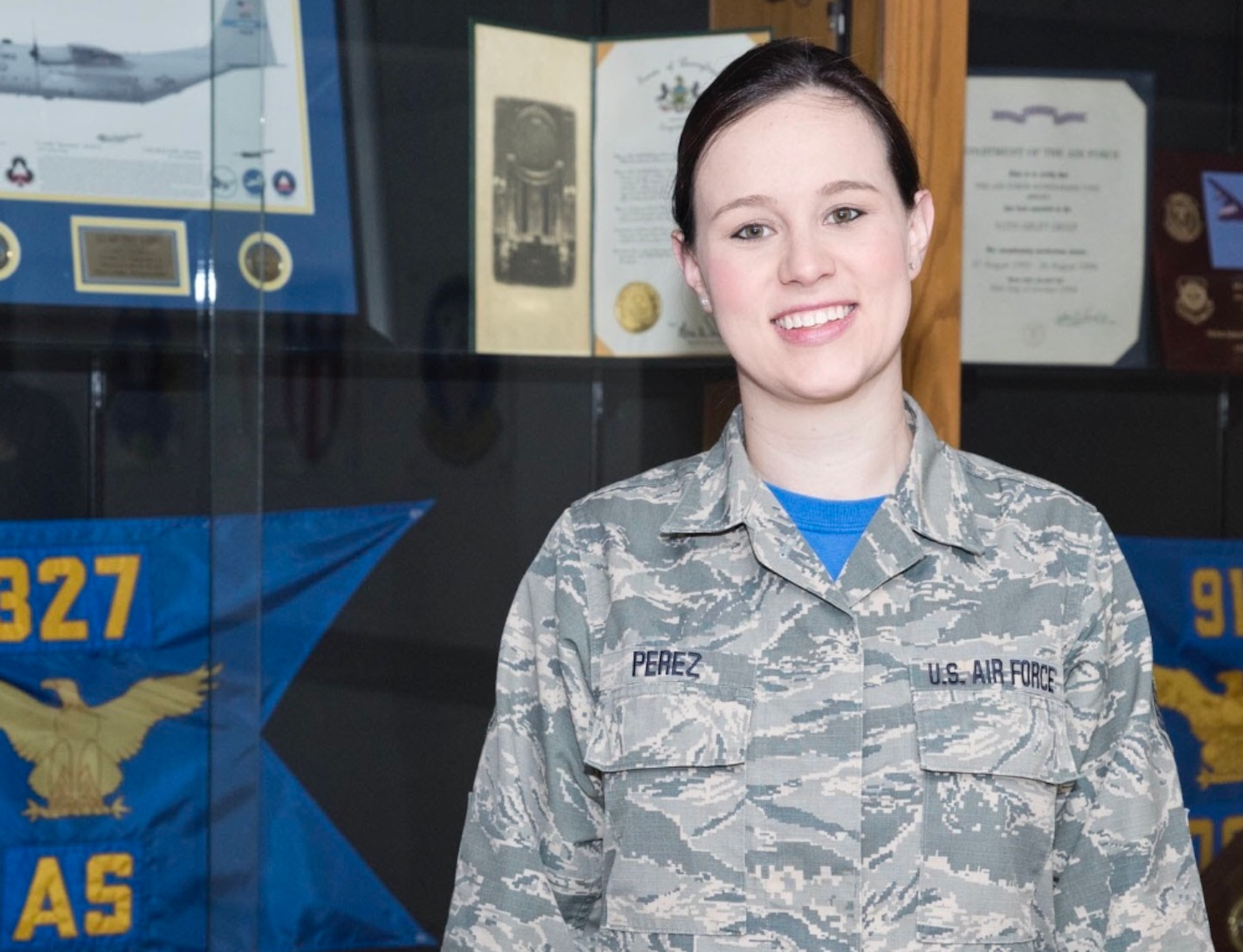 U.S. Air Force Reserve Staff Sgt. Danielle Perez poses in front of the 327th Airlift Squadron’s heritage display case. She is a commander’s support staff personnelist and is the oldest of four siblings currently stationed at Little Rock Air Force Base. (Courtesy photo)