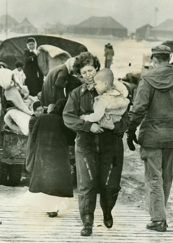 U.S. Air Force Capt. Tone Nobile, a flight nurse, comforts a tiny war victim aboard a Far East Air Forces 315th Air Division transport, during Operation Christmas Kidlift, the evacuation of almost 1,000 orphans from Seoul to safety in South Korea. (U.S. Air Force Photo)