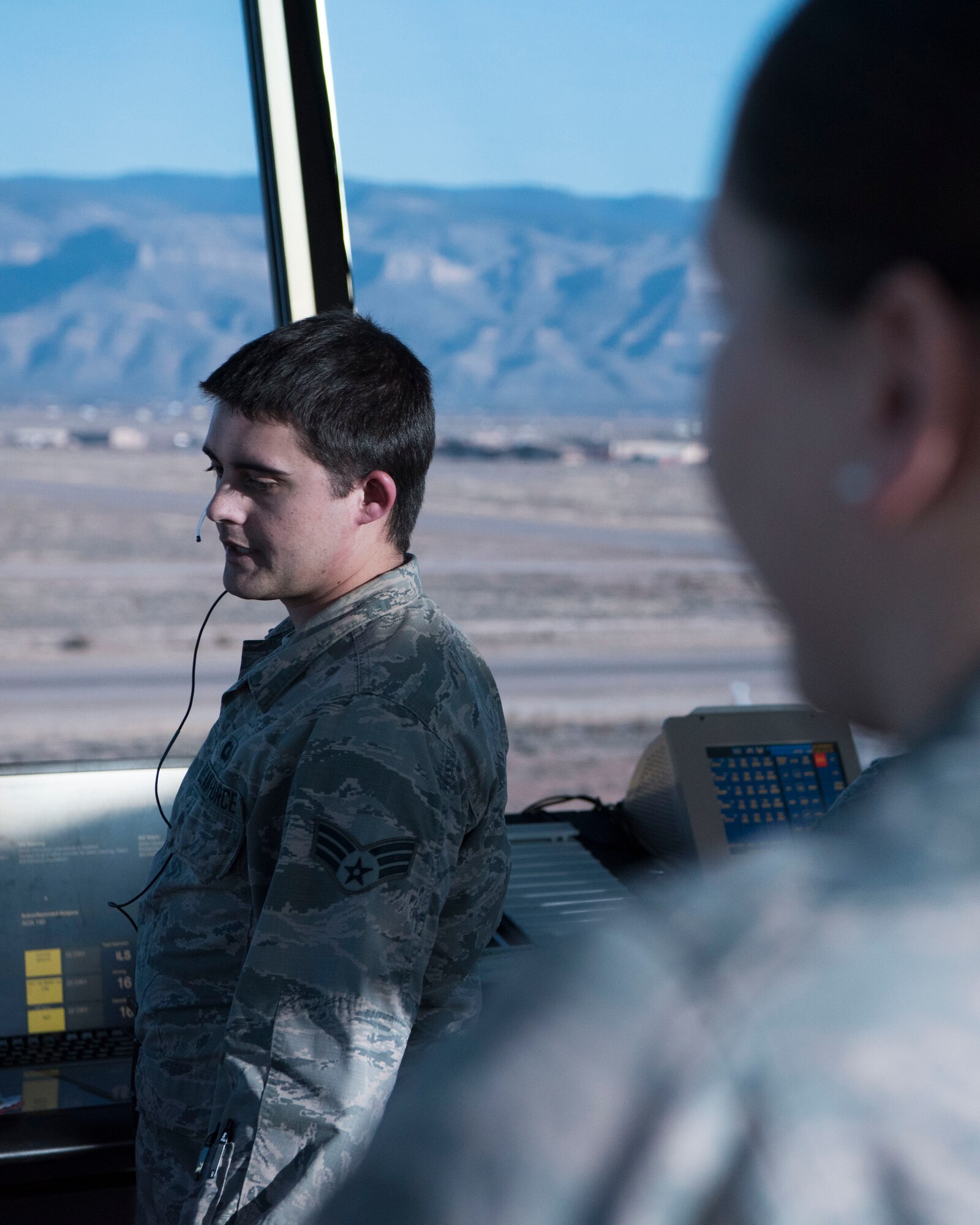(From left to right) Senior Airman Jakob Powers, 54th Operations Support Squadron air traffic controller, gives a traffic call while being observed by Staff Sgt. Kristin Owens, 54th OSS watch supervisor, Dec. 18, on Holloman Air Force Base, N.M. Holloman is home to one of the most complex airfields in the Air Force because all three of the runways intersect in the shape of the number four (U.S. Air Force photo by Staff Sgt. BreeAnn Sachs)