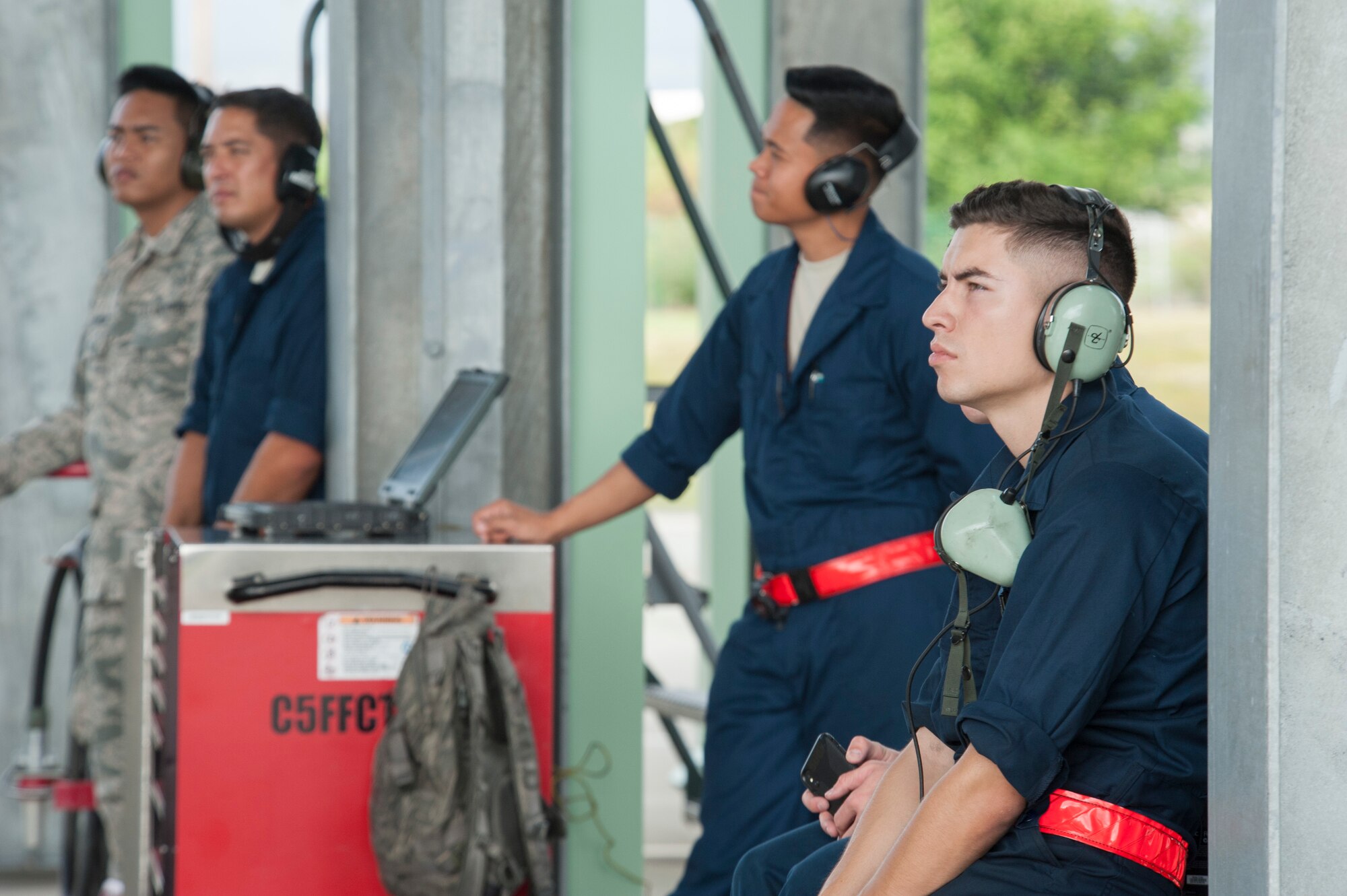 Active duty and Hawaii Air National Guard crew chiefs observe flightline operations after prepping an F-22 Raptor for flight Dec. 10, 2018