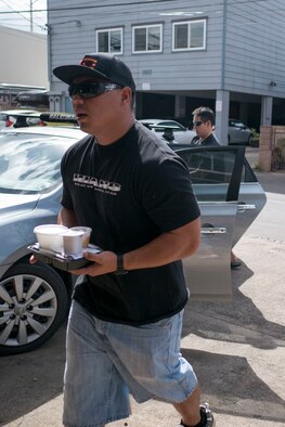 Tech. Sgt. Randall Kobayashi and Staff Sgt. John Quijano, from the Hawaii Air National Guard’s 154th Logistics Squadron, prepares to deliver a meal to a disabled resident Dec. 17, 2018