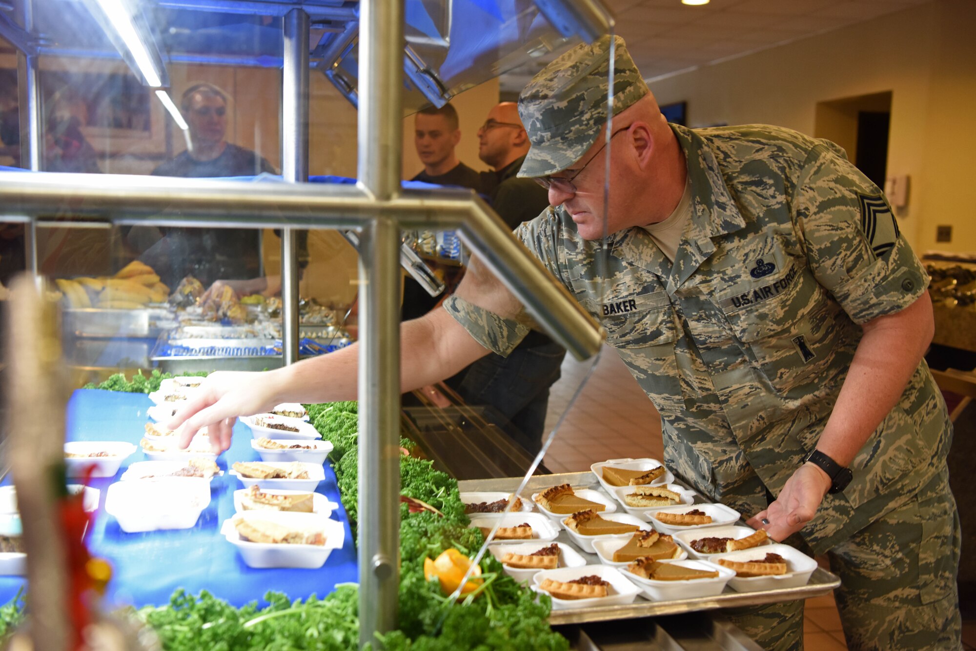 U.S. Air Force Chief Master Sgt. Robert Baker, 8th Communication Squadron chief enlisted manager, refills deserts during a holiday meal at Kunsan Air Base, Republic of Korea, Dec. 25, 2018. 8th Fighter Wing leadership served this meal to Airmen to help boost morale around the holidays. (U.S. Air Force photo by Staff Sgt. Joshua Edwards)