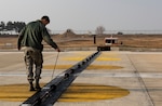 U.S. Air Force Airman 1st Class Zane Mammon, 8th Civil Engineer Squadron electical power production specalist, adjusts a rubber support on a barrier arresting kit at Kunsan Air Base, Republic of Korea, Dec. 19, 2018. Aircraft arresting systems are designed to safely stop an aircraft that's experiencing an in-flight emergency and cannot land without causing damage. (U.S. Air Force photo by Senior Airman Stefan Alvarez)