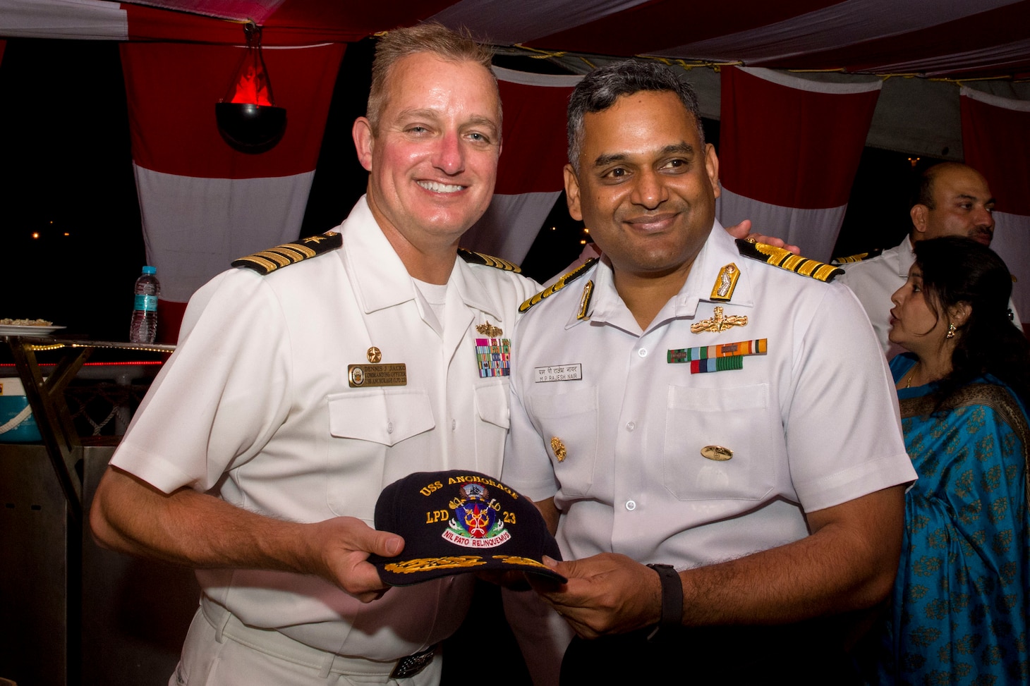 VISAKHAPATNAM, INDIA (Dec. 24, 2018) U.S. Navy Capt. Dennis Jacko, commanding officer of the San Antonio-class amphibious transport dock ship USS Anchorage (LPD 23), left, presents a gift to Capt. Rajesh Nair, commanding officer of the Indian navy destroyer INS Rajput (D 51), during an Indian hosted reception, while conducting a cooperative deployment with the Indian navy. Anchorage is deployed as a part of the Essex Amphibious Ready Group (ARG) and 13th Marine Expeditionary Unit (MEU).