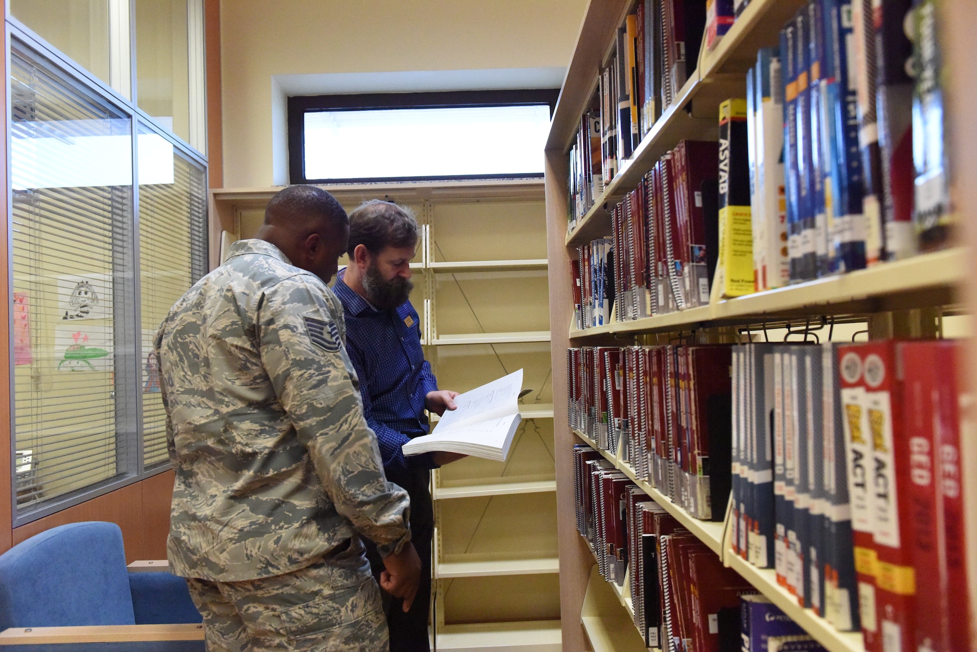 A librarian helps a service member find a book.