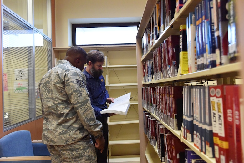 Thomas Lynch, 39th Force Support Squadron supervisory librarian, helps a service member find a book for a college course at Incirlik Air Base, Turkey, Nov. 27, 2018.
