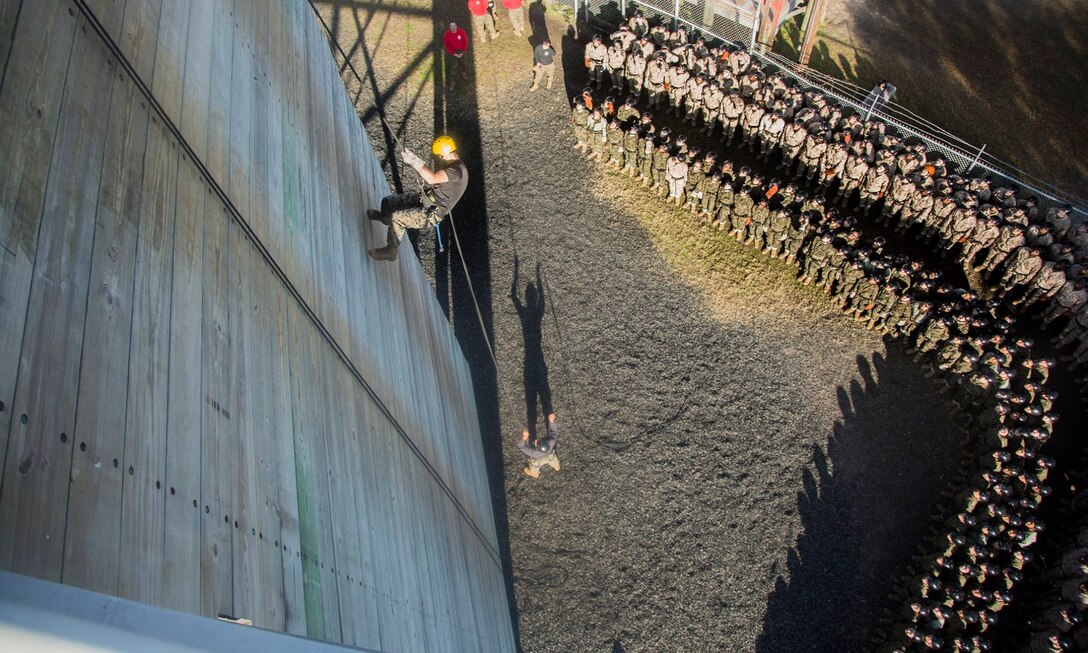 Sgt. Lane Fontaine, an instructor with Field Company, Weapons and Field Training Battalion, demonstrates how to properly rappel down a wall to recruits of Alpha Company, 1st Recruit Training Battalion, and Papa Company, 4th Recruit Training Battalion Dec. 26, 2018, on Marine Corps Recruit Depot Parris Island, S.C. Rappel tower instructors like Fontaine, 23, from Carthage, N.Y., are responsible for demonstrations as well as sending the recruits down the rappel tower. (U.S. Marine Corps photo by Lance Cpl. Carlin Warren)