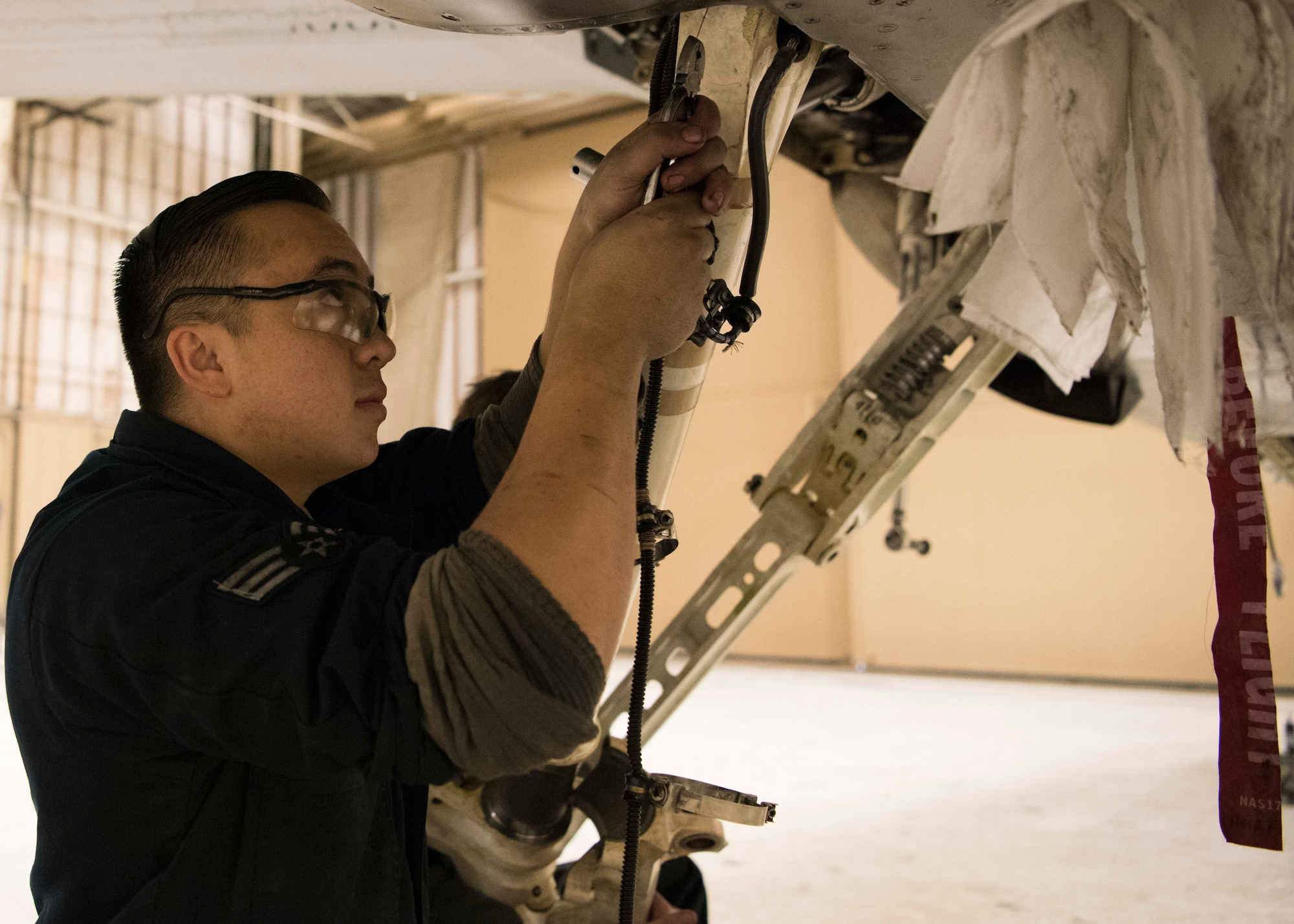 Senior Airman Jordan Eveland, 314th Aircraft Maintenance Unit dedicated crew chief, performs maintenance on an F-16 Fighting Falcon Oct. 18 on Holloman Air Force Base, N.M. As a DCC Eveland is assigned to a specific aircraft, and is responsible for all fight essential maintenance on his aircraft. (U.S. Air Force photo by Staff Sgt. BreeAnn Sachs)