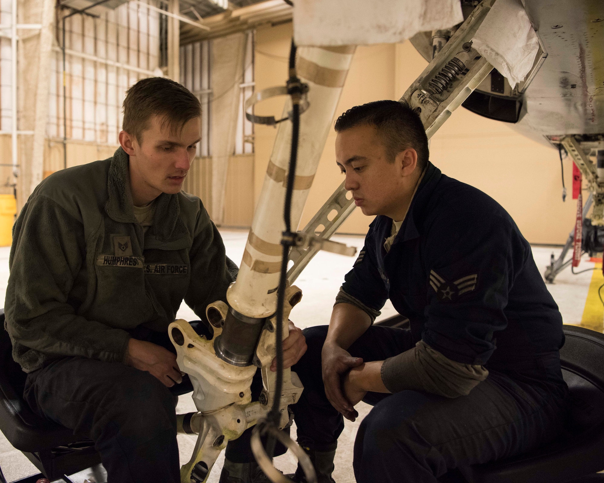 (From left to right) Staff Sgt. Austin Humphres, 849th Aircraft Maintenance Squadron dedicated crew chief, and Senior Airman Jordan Eveland, 314th Aircraft Maintenance Unit DCC, perform maintenance on an F-16 Fighting Falcon Oct. 18 on Holloman Air Force Base, N.M. As DCCs, Humphres and Eveland are assigned to specific aircraft, and are responsible for all fight essential maintenance on their aircraft. (U.S. Air Force photo by Staff Sgt. BreeAnn Sachs)