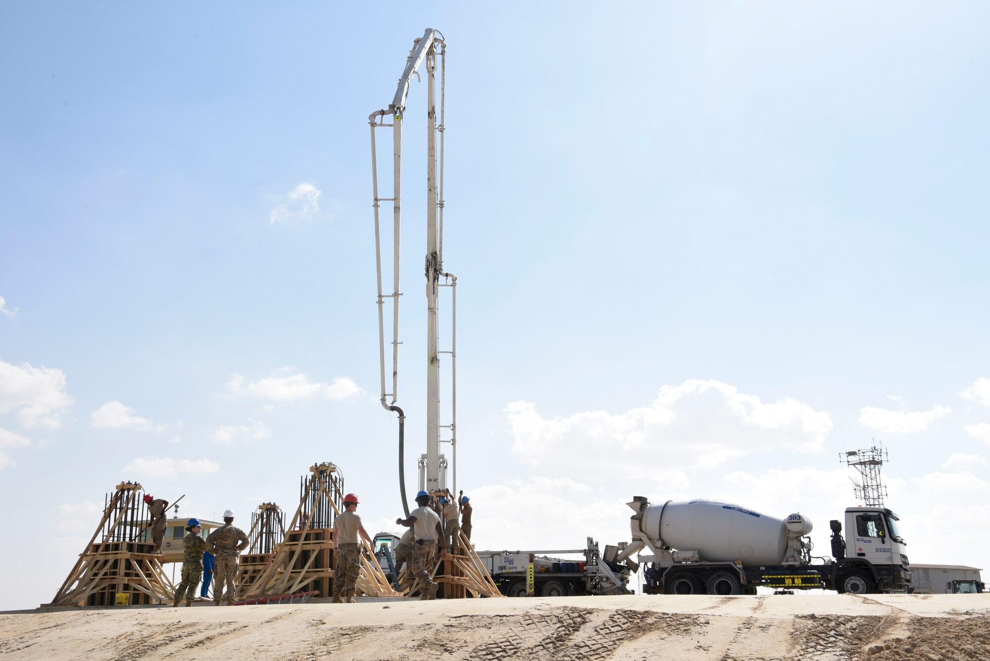 Members of the 577th Expeditionary Prime Base Engineer Emergency Force pour cement into the foundation system to support a build during construction, Dec. 23, 2018 at Al Dhafra Air Base, United Arab Emirates.