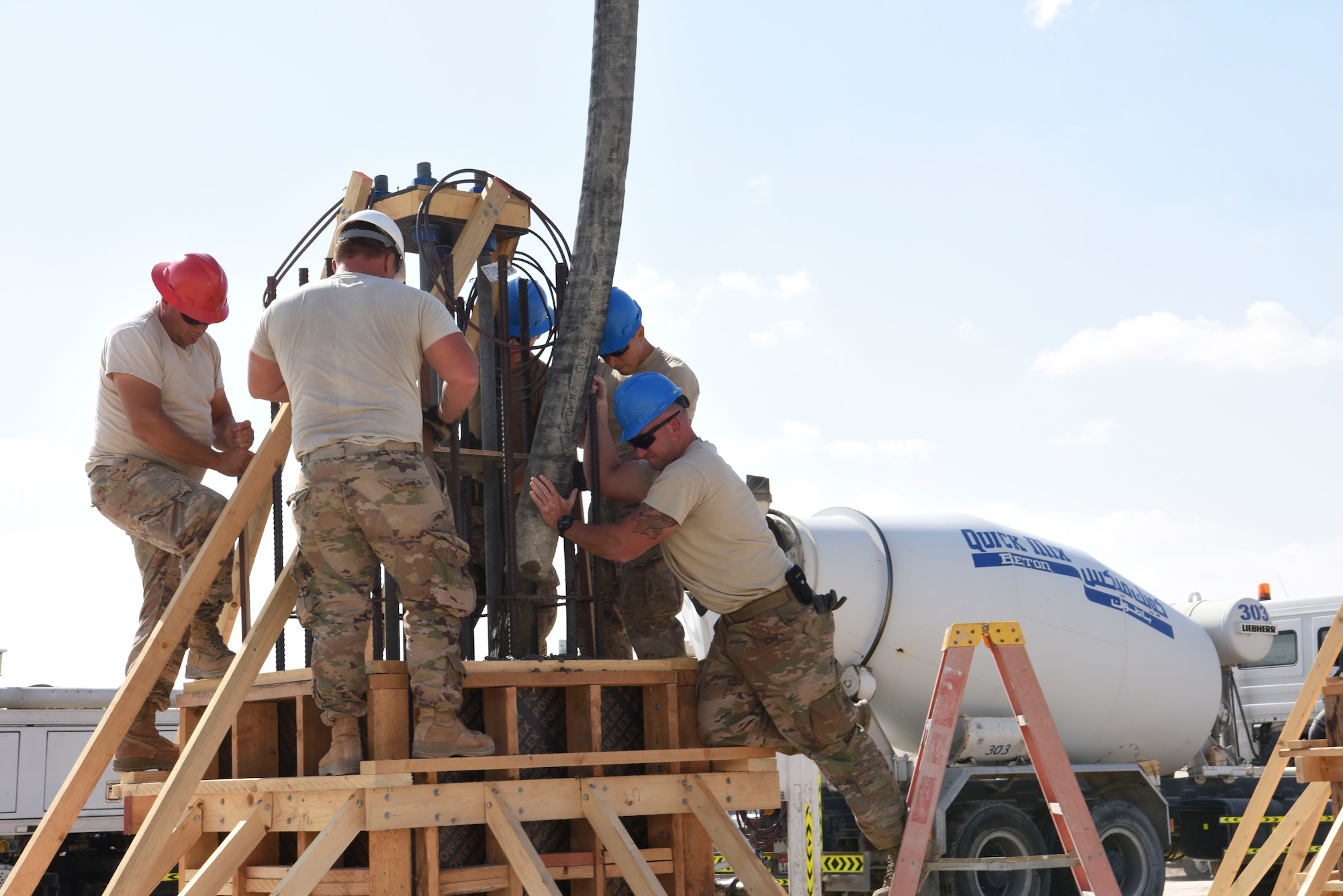 Members of the 577th Expeditionary Prime Base Engineer Emergency Force pour cement into the foundation system to support a build during construction, Dec. 23, 2018 at Al Dhafra Air Base, United Arab Emirates.