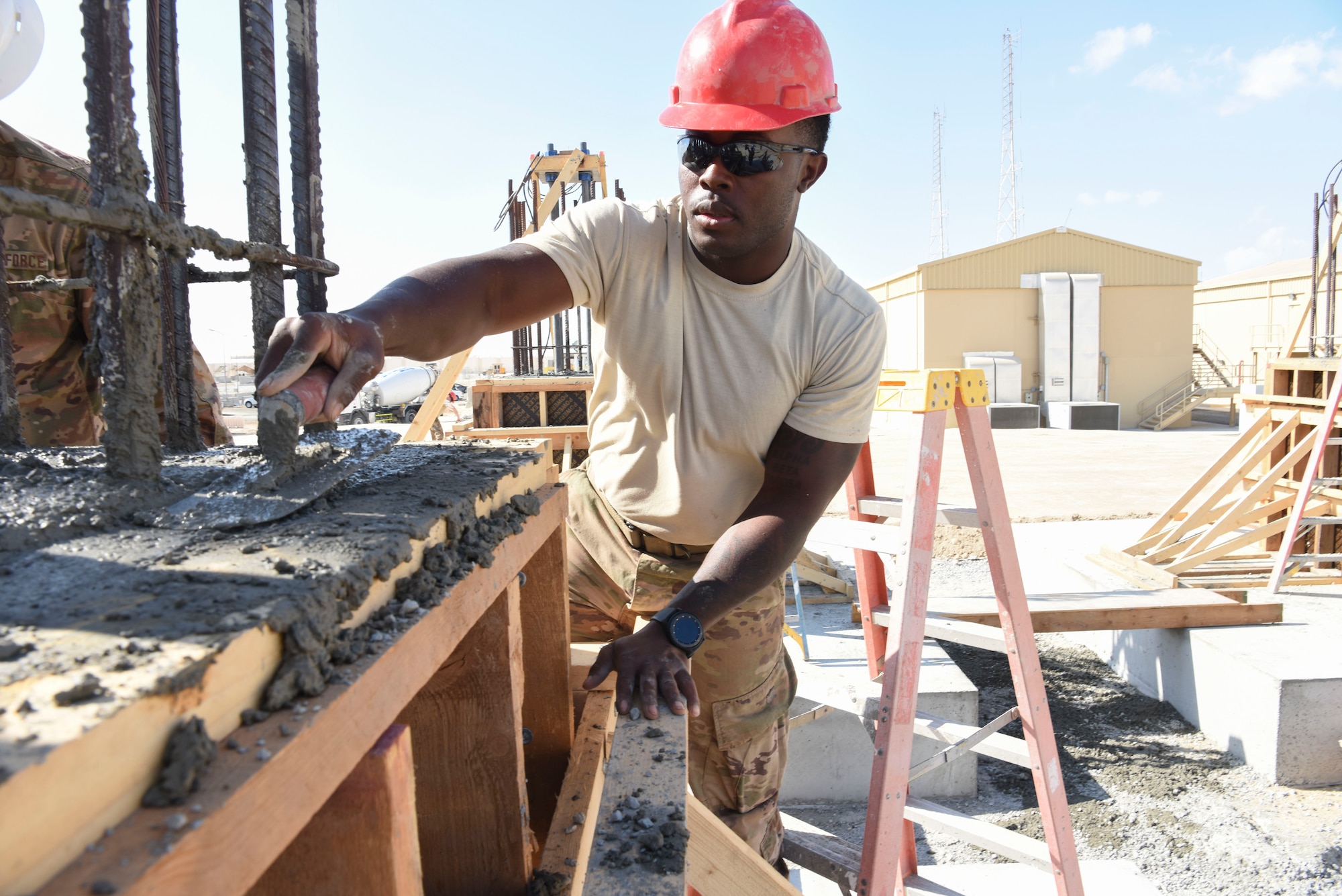 Senior Airman Dekota Newson, 577th Expeditionary Prime Base Engineer Emergency Force heavy equipment operator, remove excess cement from the foundation system to support a build during construction, Dec. 23, 2018 at Al Dhafra Air Base, United Arab Emirates.