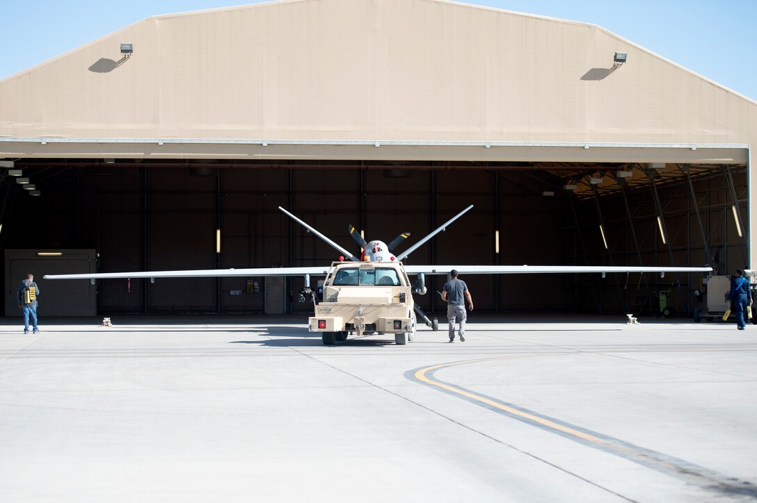 Maintainers assigned to the 451st Expeditionary Aircraft Maintenance Squadron tow an MQ-9 Reaper into a hangar at Kandahar Airfield, Afghanistan Dec 20, 2018.