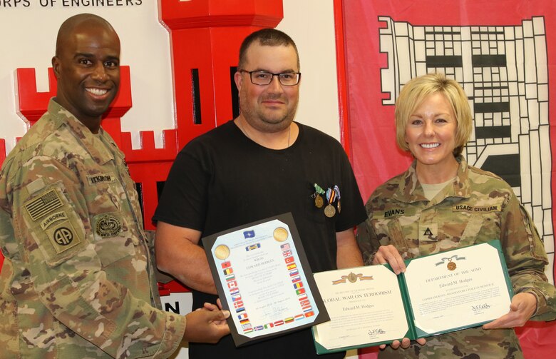 Command Sergeant Major Nate Atkinson and Annette Evans presents Ed Hodges with his End of Tour awards during an impromptu ceremony prior to Hodges’ departure.