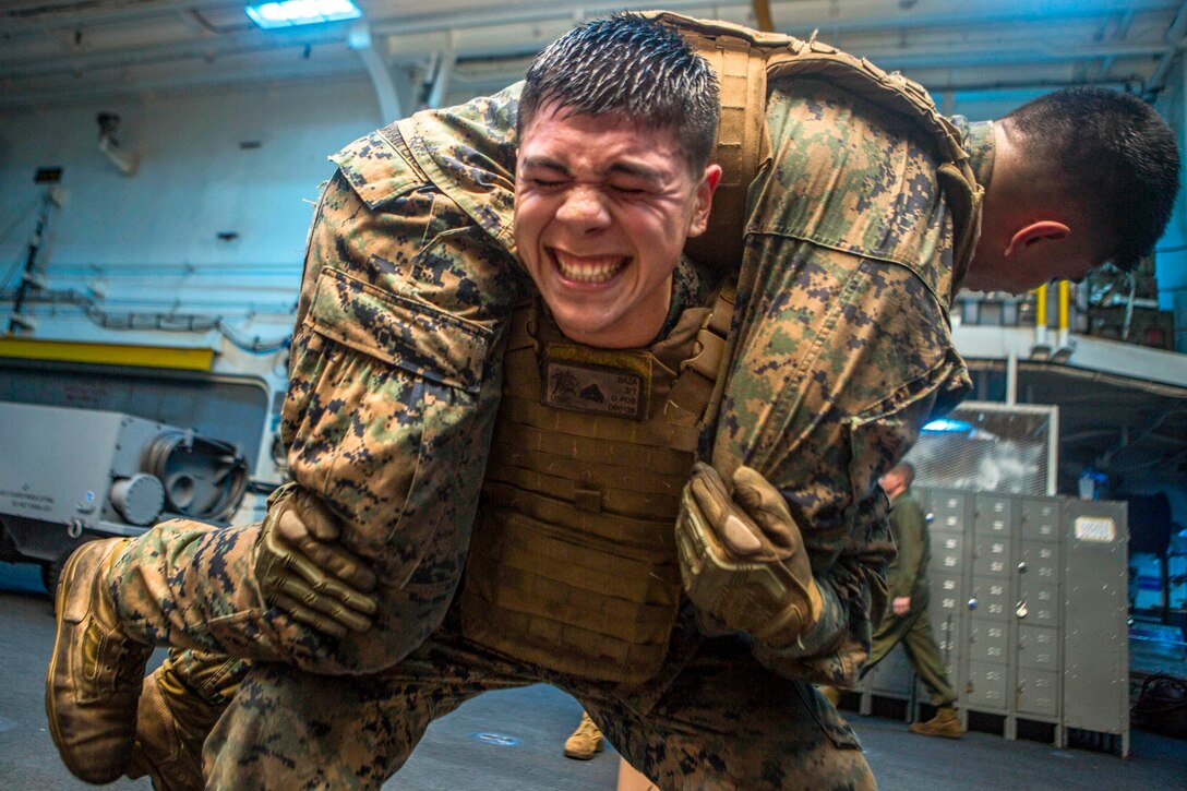 A Marine carries another Marine during martial arts training.