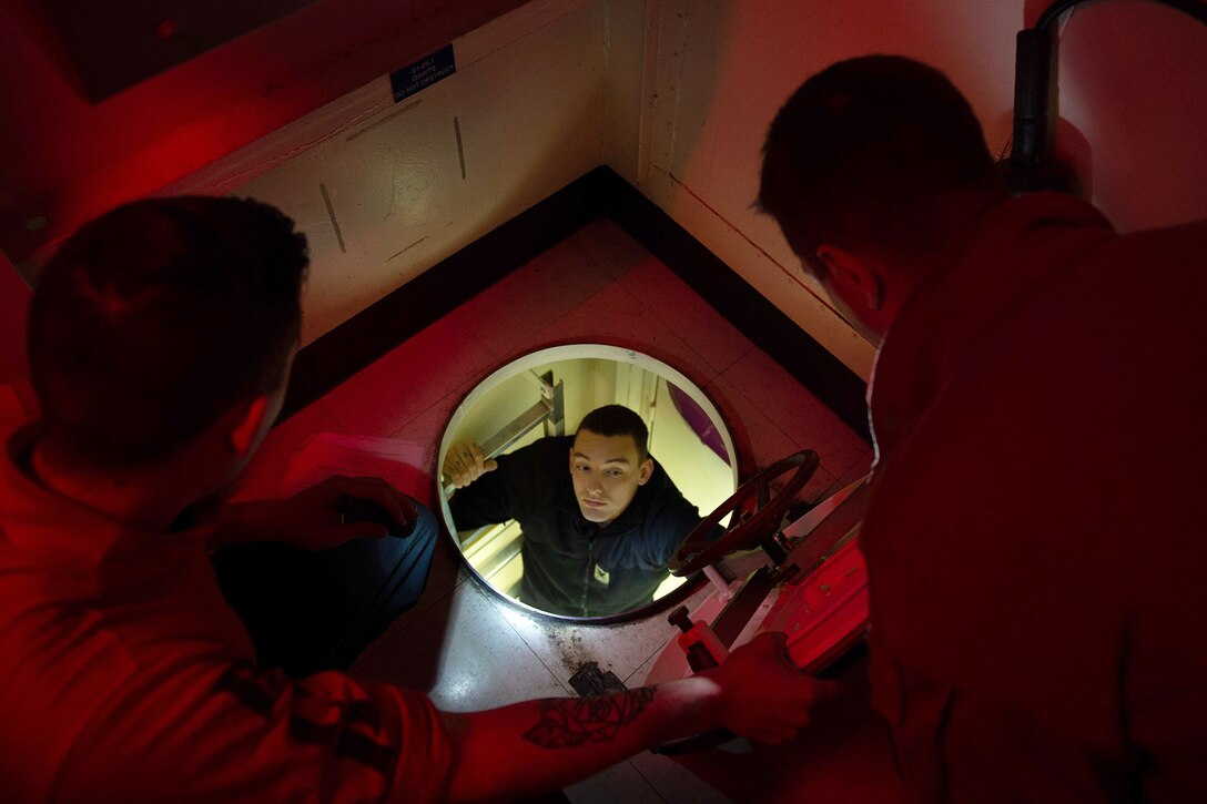 Sailors conduct maintenance aboard a military ship.