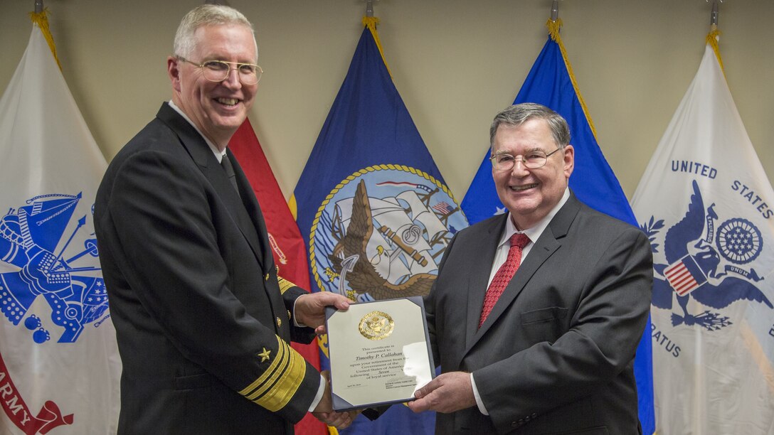 Defense Contract Management Agency Director Navy Vice Adm. David Lewis presents Timothy Callahan, DCMA executive director of Contracts, with a certificate during Callahan’s retirement ceremony at Fort Lee, Virginia, Jan. 31. (DCMA photo by Elizabeth Szoke)
