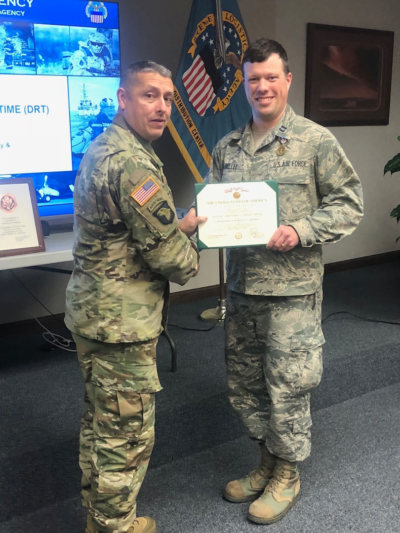 DLA Distribution commanding general Army, Brig. Gen. John S.  Laskodi presents Air Force Capt. Joshua McNelley with a Defense Meritorious Service Medal for his service as Aide-de-Camp to the NATO Air Command-Afghanistan and 9th Air and Space Expeditionary Task Force – Afghanistan from October 14, 2016 to April 12, 2017.