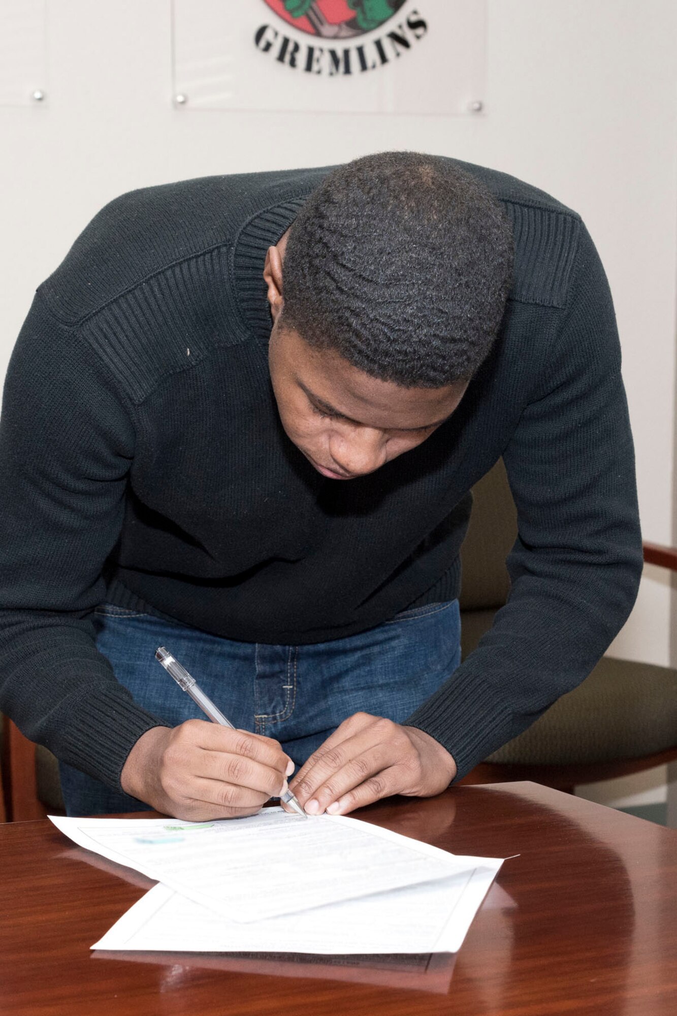 U.S. Air Force Reserve Senior Airman Derrick Barnes, a 913th Maintenance Squadron crew chief, signs re-enlistment paperwork at Little Rock Air Force Base, Ark., Jan. 31, 2018. Barnes signed on for his second six-year enlistment. (U.S. Air Force photo by Master Sgt. Jeff Walston/Released)