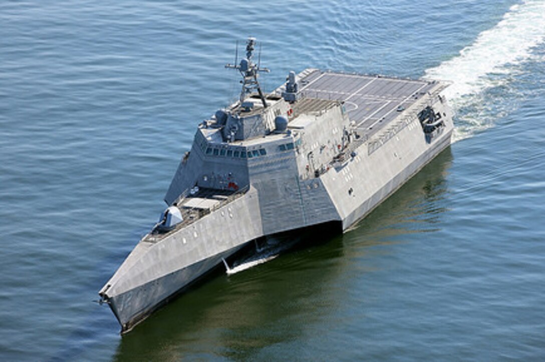 A Navy ship moves across the water.