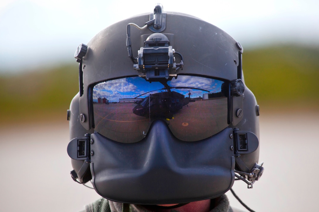 A Black Hawk helicopter is reflected in helmet worn by a guardsman.