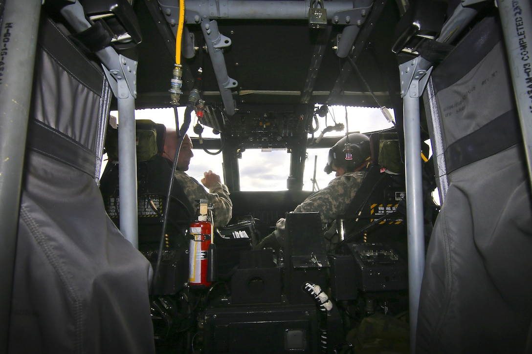 Two guardsmen sit in a cockpit about to take off.