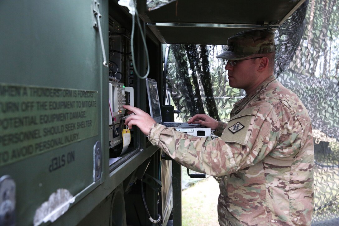 U.S. Army Spc. Jacob York checks the status of the satellite link
