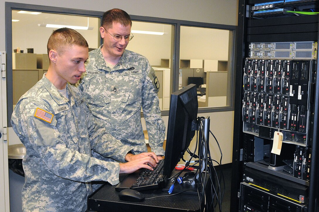 U.S. Army Warrant Officer Ashton Hanisch, left, network infrastructure service specialist, and Staff Sgt. Michael Reiprich, senior security analyst, with the South Dakota Army National Guard’s Cyber Protection Team 174 conduct cyber protection training at Camp Rapid