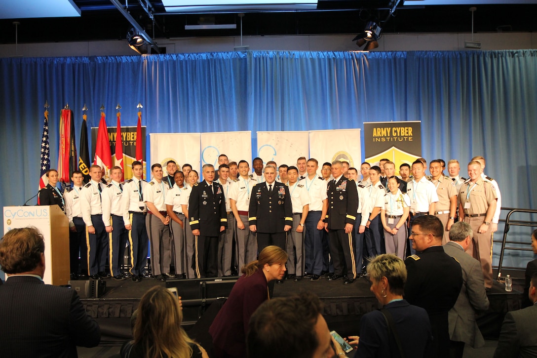 Gen. Mark Milley, Lt. Gen. Paul Nakasone (left) and Lt. Gen. Robert Caslen, Jr. (right) stand with cadets, lieutenants and captains associated with the cyber force, to include this year’s winners of the All-Army CyberStakes competition