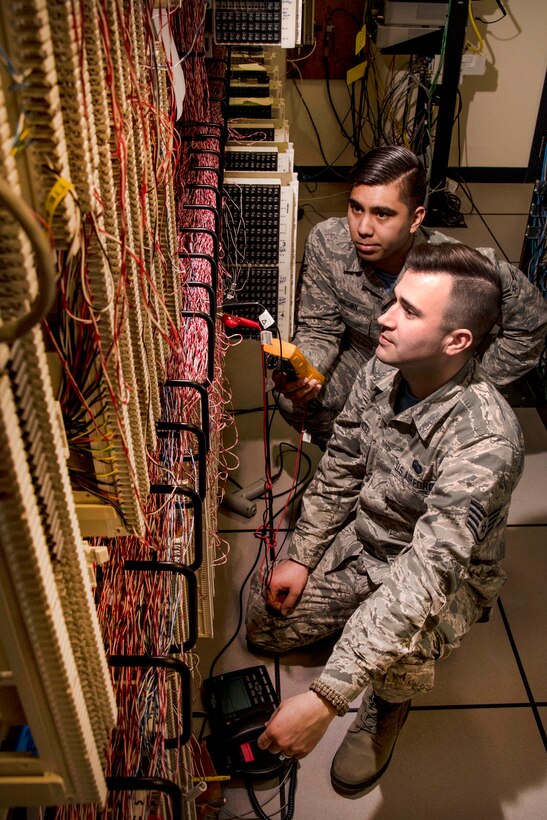 Two airmen test phone lines.