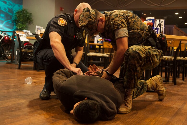 Military police officers with the Provost Marshall’s Office, detain a simulated victim during a night exercise at the Kahuna’s Sports Bar & Grill, Marine Corps Base Hawaii (MCBH), Jan. 24, 2017. The K-9 unit continuously works to improve mission readiness with realistic training exercises that encompass tracking, escorting, searches and detaining. Military police officers and their working dogs help preserve the peace while also projecting their presence as a deterrent from crime aboard MCBH. (U.S. Marine Corps photo by Cpl. Jesus Sepulveda Torres)